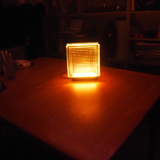 Amber lamp lighting up a wooden dining table in the evening